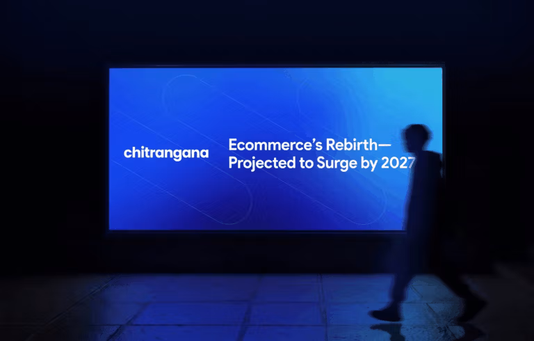 Illuminated blue billboard reading 'Ecommerce's Rebirth — Projected to Surge by 2027' with a silhouette walking past